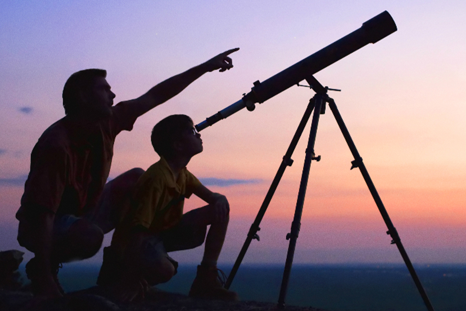 Padre e hijo mirando por telescopio en Guadarrama